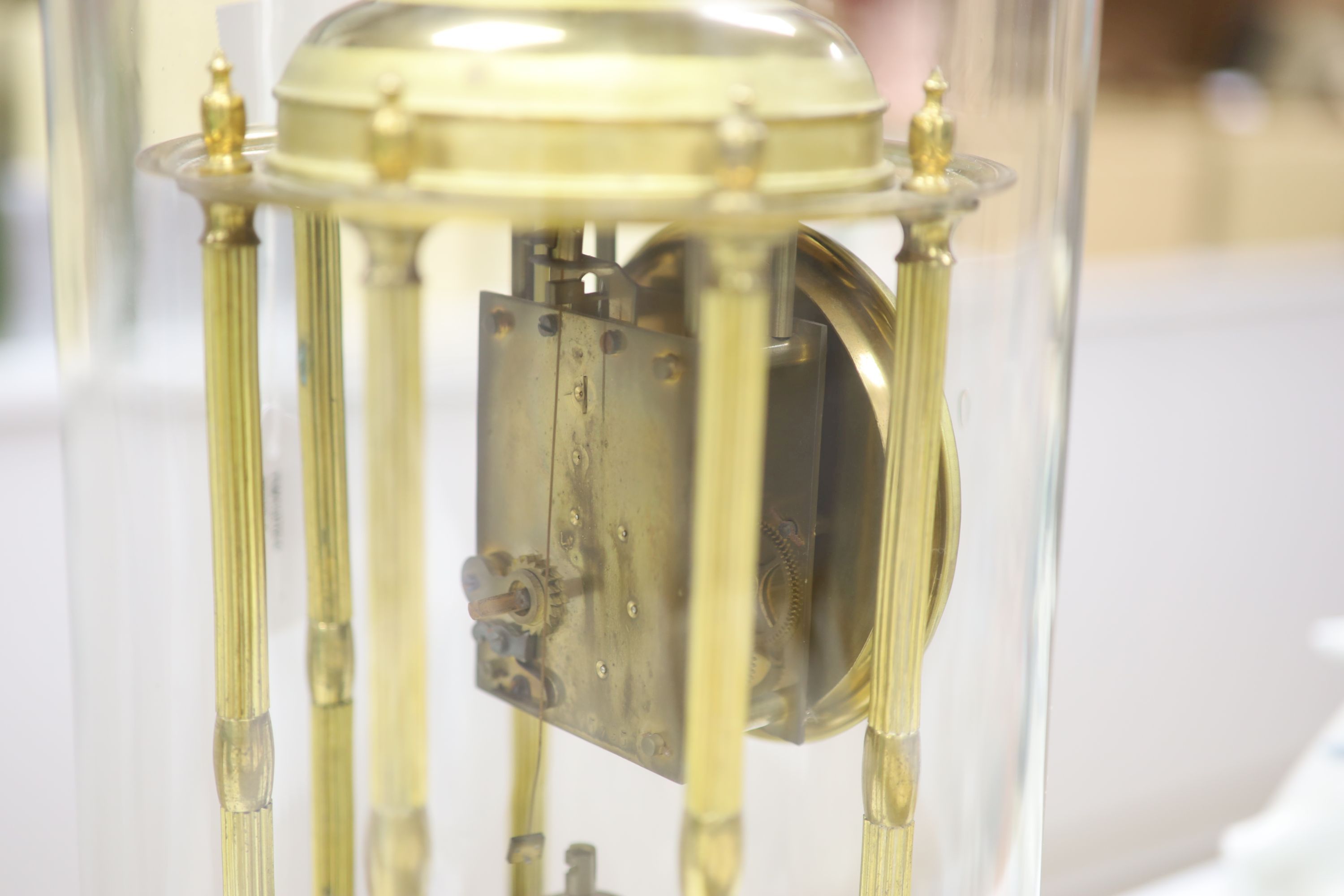 A gilt brass Anniversary clock having swag-decorated enamel Arabic dial, on circular wooden plinth under glass dome, height 42cm